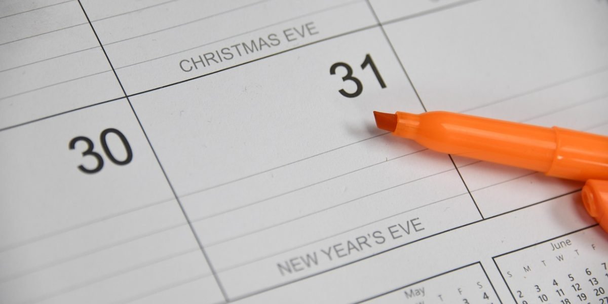 An individual meticulously reviews a calendar, highlighting the importance of managing application deadlines.
