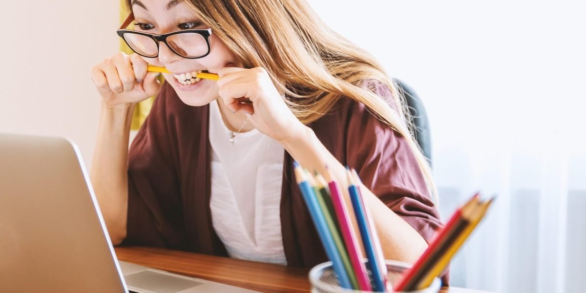 A student thoughtfully researching different college options and their admission requirements.