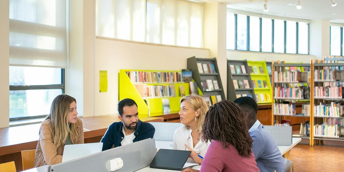 A diverse team collaborates in a university setting, working together on a project.
