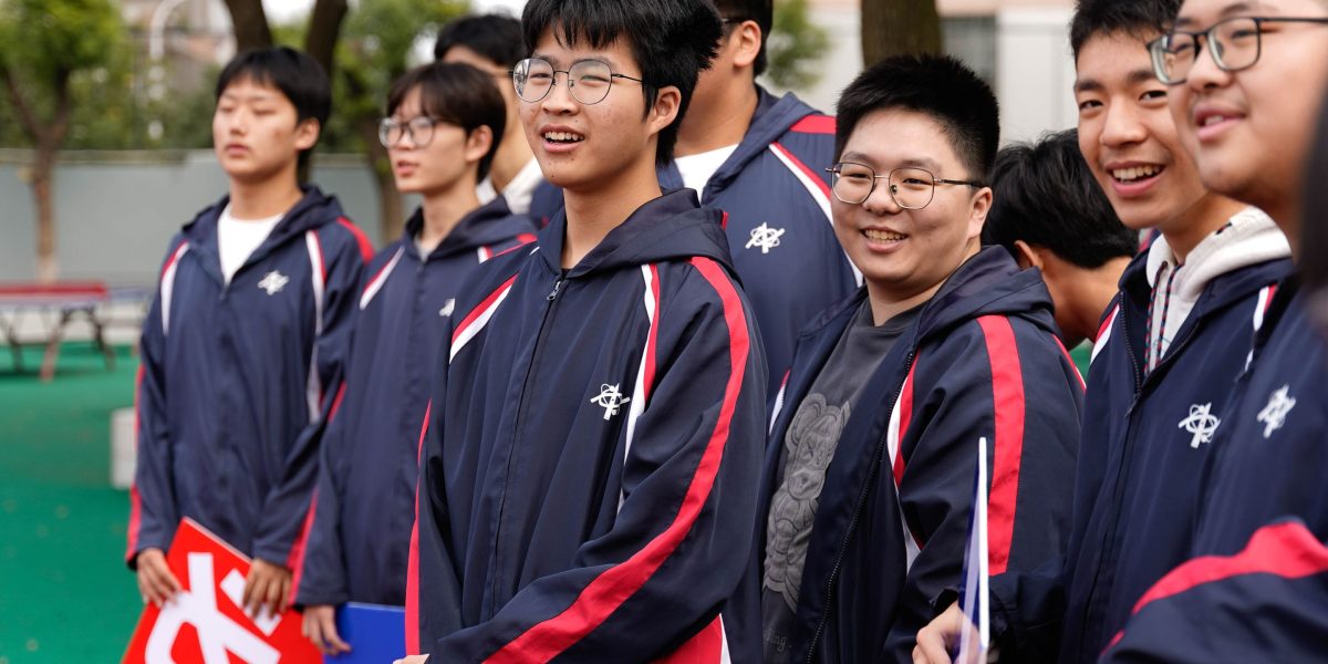 University students cheering enthusiastically at a lively campus sporting event.