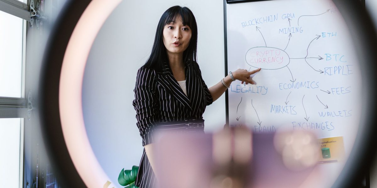 An individual actively explaining a concept on a whiteboard, symbolizing the process of clarifying complex ideas.