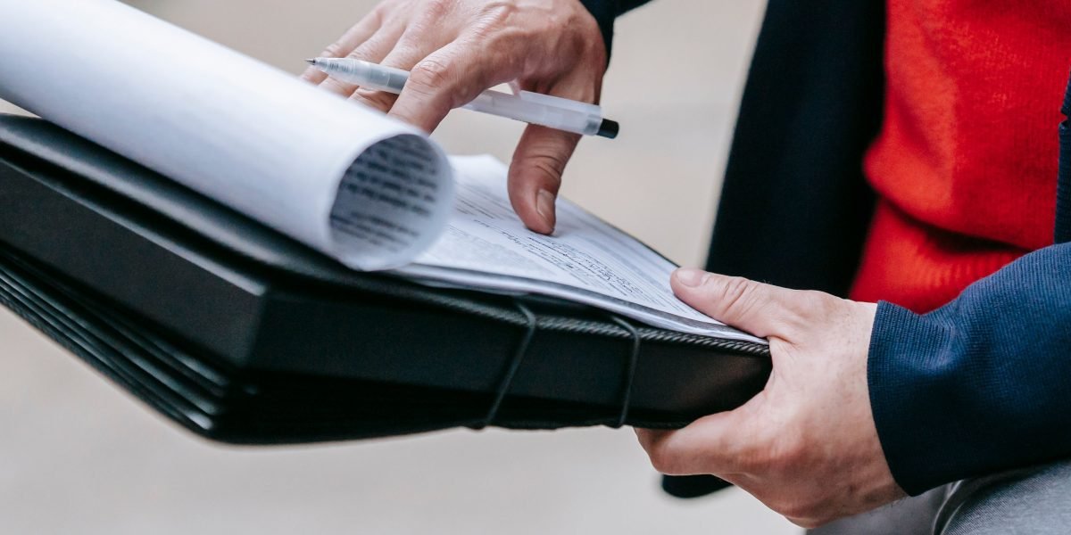 A person meticulously comparing information from multiple documents or screens, demonstrating thorough data validation.