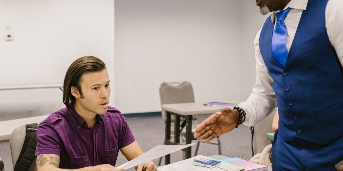 A professor and a student engaged in a focused one-on-one discussion, reflecting personalized academic support.
