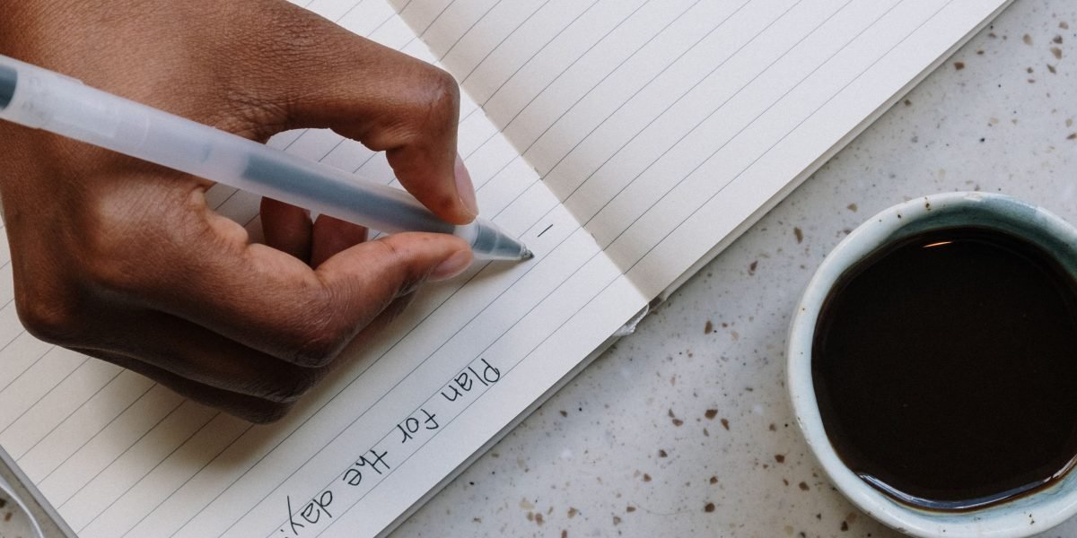 A focused individual writing notes and planning, symbolizing the effort put into crafting a compelling college application.