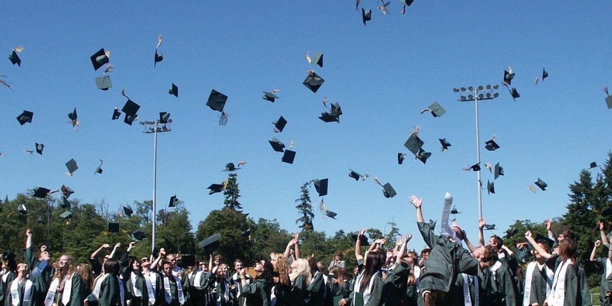 A group of cheerful graduates celebrating their accomplishments, representing positive student outcomes.