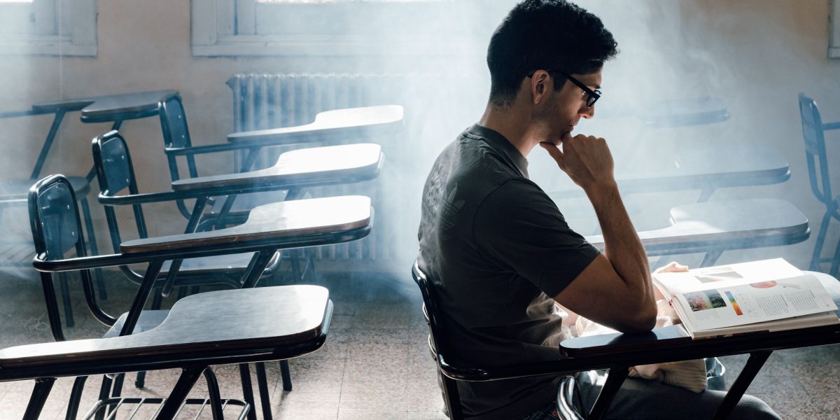 A student deeply pondering their various college options, reflecting the initial excitement and confusion of the application process.